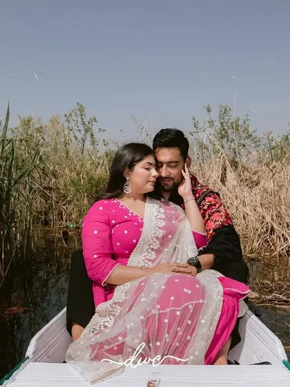 An intimate pre-wedding portrait of a couple in a shikara, nestled amongst the reeds of a serene lake in Kashmir.