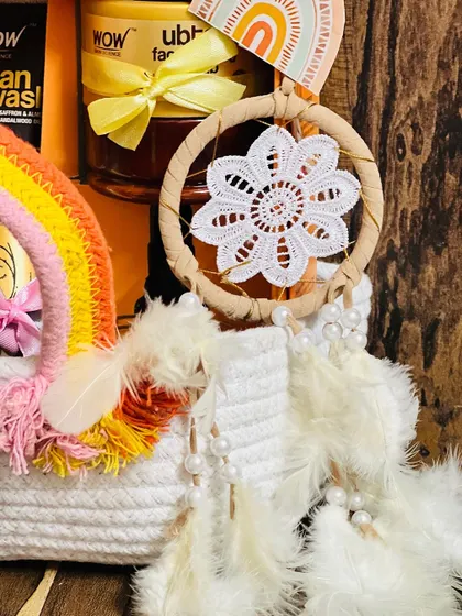 A close-up of the handmade details in the rainbow-themed hamper. This crochet dreamcatcher adds a beautiful, artisanal touch to the gift.