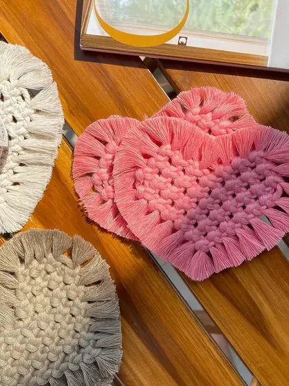 Our macrame heart coasters are another lovely option for your home. This photo shows several sets in different colors, including a pretty pink and a neutral beige.