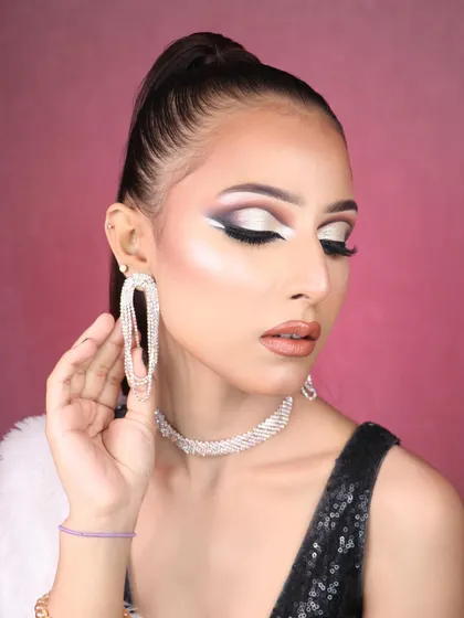The high ponytail and dramatic earrings complete this high-fashion, editorial-worthy look.