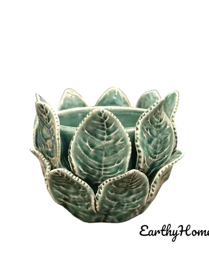 A beautiful tealight candle holder with a leaf-inspired design. The ceramic material and intricate details create a warm and inviting glow.