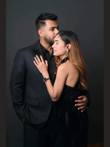 An elegant and intimate studio portrait. The all-black attire and simple background create a sophisticated and modern look for this couple's photoshoot.