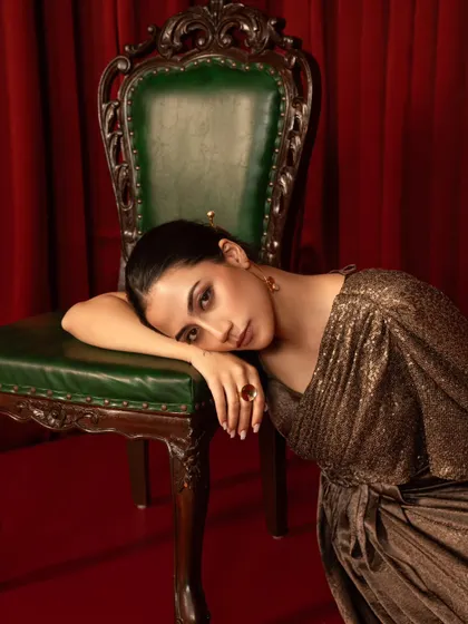 A quiet, emotive portrait from a brand campaign. The deep colors and the model's soft expression create a sense of intimacy and luxury.