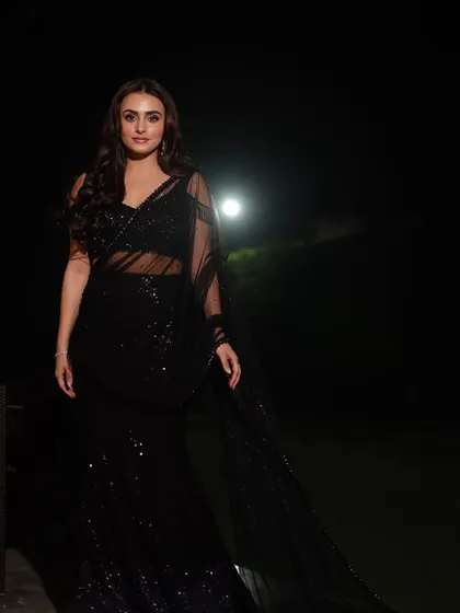 A soft and elegant portrait in a sheer black saree. The lighting creates a gentle glow, emphasizing the model's features and the delicate fabric.