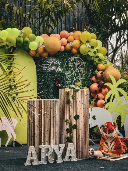 Another view of the outdoor jungle party. The combination of palm tree cutouts, a balloon arch, and animal props creates a vibrant and exciting atmosphere.