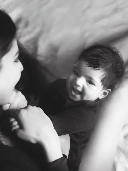 The pure joy in a baby's smile as they look up at their mother. This candid black and white shot is full of life and love.