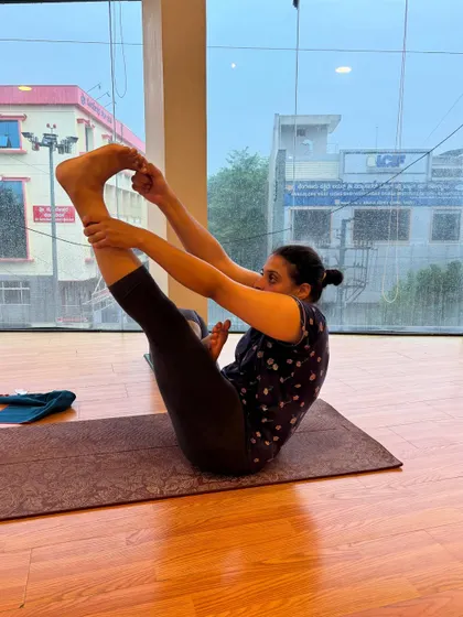A student holds a variation of boat pose, showing the different levels of challenge we offer in our classes.