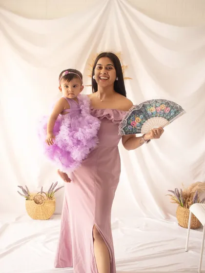 A mother and her one-year-old daughter in matching lavender tones. This pre-birthday shoot is full of smiles and sweet moments.