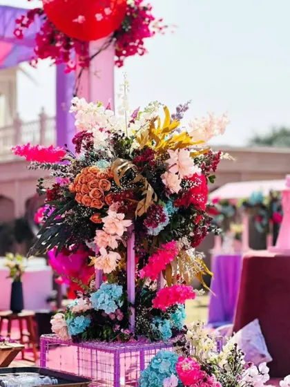 A large, vibrant floral arrangement that serves as a stunning decor piece at a colorful daytime event.