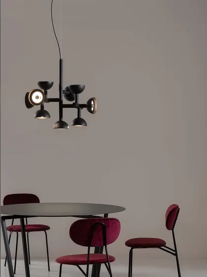 The Sibilla suspension light by Karman. From a central aluminum stem, arms branch out, ending in spherical caps that diffuse light in all directions, a clear reference to Dutch neoformalism.