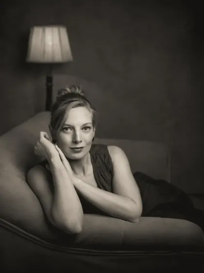 A duplicate of ID 61, this black and white portrait of Sonia on a chaise lounge enhances the classic, cinematic feel of the image, focusing on her expression and the elegant lines of the pose.