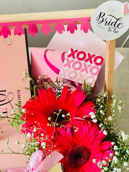 A detail shot of the floral arrangement and 'Bride to be' tag on the festive hamper. I use fresh flowers and custom stationery to elevate the gift.