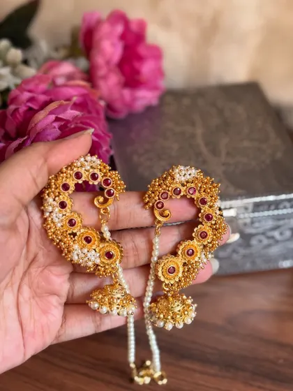 Our floral-themed karnful with red stones and golden beads. The attached pearl chain provides support and adds to the beauty of the piece.