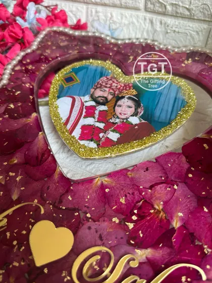 A close-up of the hanging heart detail in this 12x16 inch frame. The photo is bordered with gold glitter, making it a sparkling centerpiece.