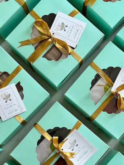 An overhead view of the naming ceremony favors, showcasing the neat arrangement and the cute stroller design on the tags.