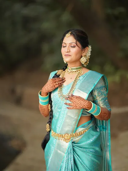 An eyes-closed shot focusing on the flawless makeup and the peaceful expression of the bride. The long, decorated braid is a key feature of this look.