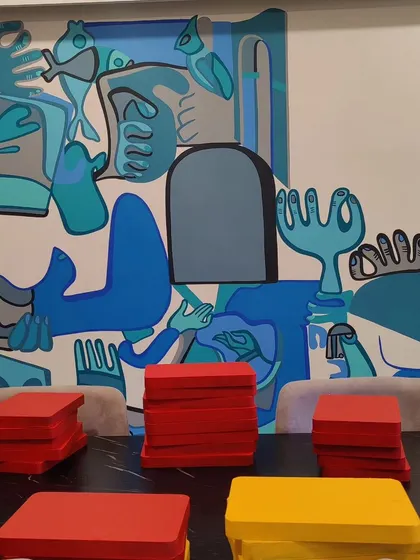 Another view of the blue abstract mural, this time with colorful blocks in the foreground, hinting at the multi-component nature of the final installation.