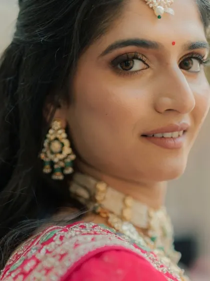 A close-up portrait that captures the fine details of the makeup and the sparkle in the bride's eyes.