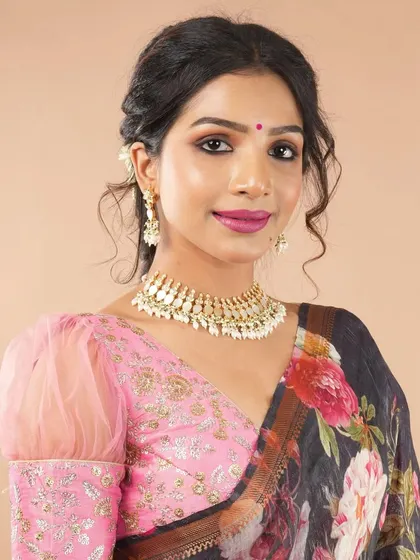 This pink embroidered blouse with sheer puff sleeves is a modern and romantic choice. It pairs beautifully with floral or lightweight sarees for a fresh, contemporary look.