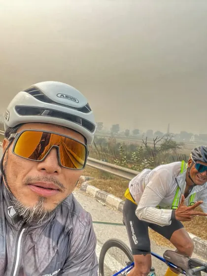 A selfie of two riders pushing through on the highway. The determination is visible on their faces.