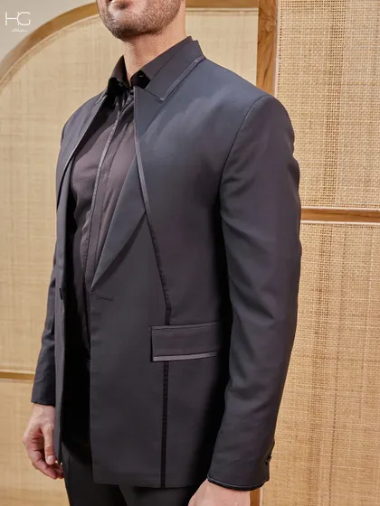 This close-up shows the craftsmanship of the lapel and pocket details. It's these small, precise touches that elevate a black suit from standard to statement.
