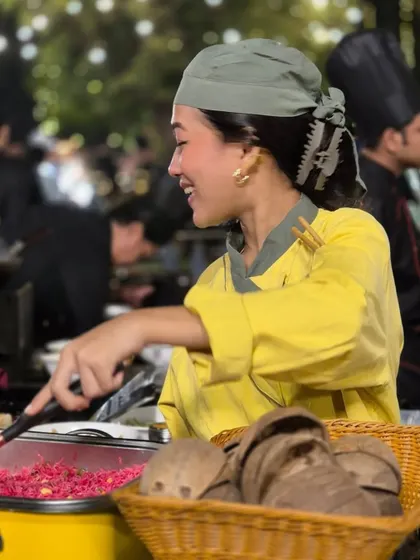 The joy of cooking is infectious. This candid shot captures one of our chefs smiling as she prepares a dish, embodying the positive and welcoming atmosphere we cultivate at our events.