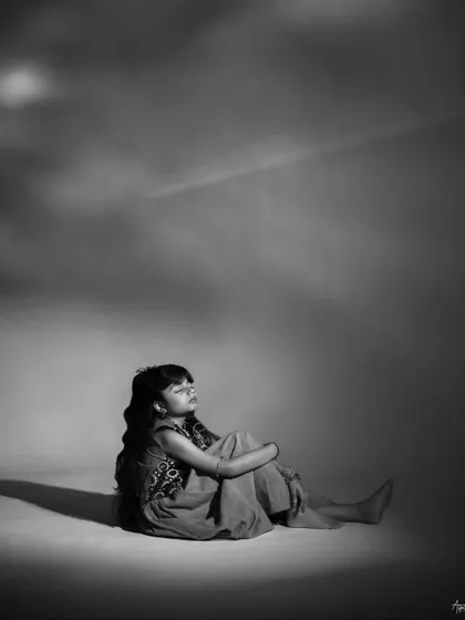 A dreamy, contemplative black and white portrait. The soft lighting and her peaceful expression create a beautiful, artistic image that feels timeless and serene.