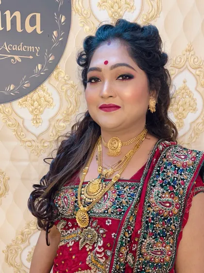 A smiling portrait of the client in the red saree, happy with her festive look.