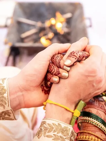 A close-up of a couple's hands clasped together during their wedding vows, a powerful symbol of their union.