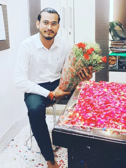 A moment of celebration in the office, surrounded by flowers.