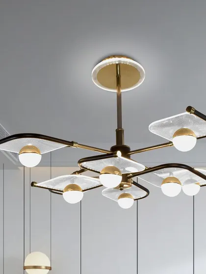 A modern chandelier with leaf-shaped glass panels and globe lights. The design is organic yet contemporary, perfect for a living or dining area.