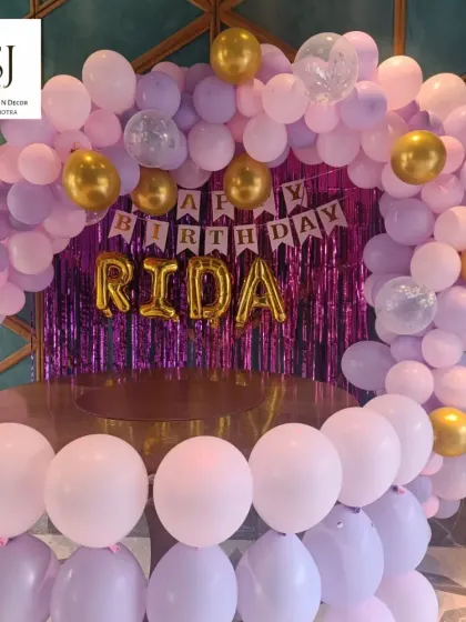 A beautiful pink and purple balloon arch with a shimmer backdrop, perfect for an at-home birthday party. This setup for Rida created a glamorous and fun atmosphere for her celebration.
