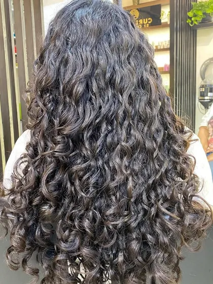 This is the goal: a full head of beautifully defined, healthy, and hydrated curls. This result was achieved by understanding the client's specific hair type and creating a routine that she can replicate at home.