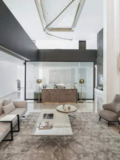 An overhead view of a living space in the Silhouette project, showing an open-plan layout that encourages family togetherness. The neutral palette and clean lines are complemented by a unique, artistic chandelier.