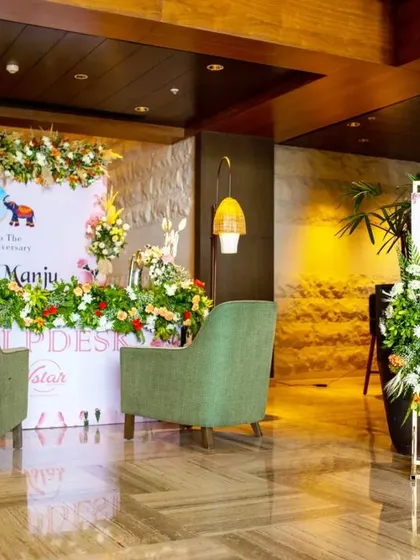 A simple and elegant help desk setup, with comfortable green chairs and a floral backdrop, ensuring guests are welcomed warmly.