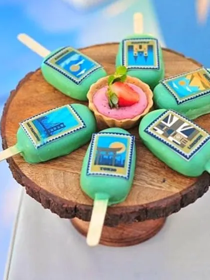 A display of the travel-themed cakesicles and strawberry tarts.