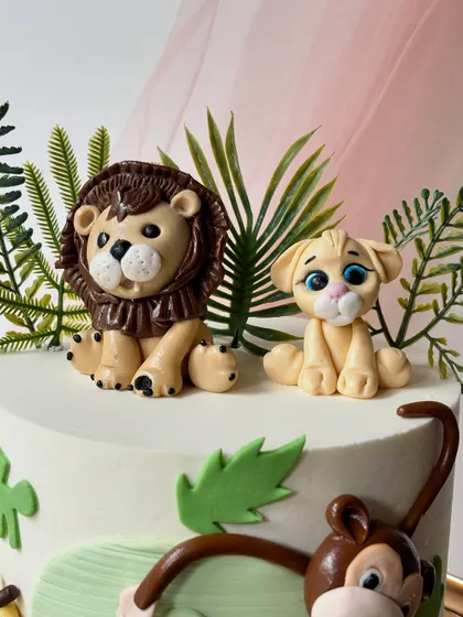 A close-up of the hand-sculpted lion and lion cub toppers. I focus on creating cute, expressive faces to bring each character to life.