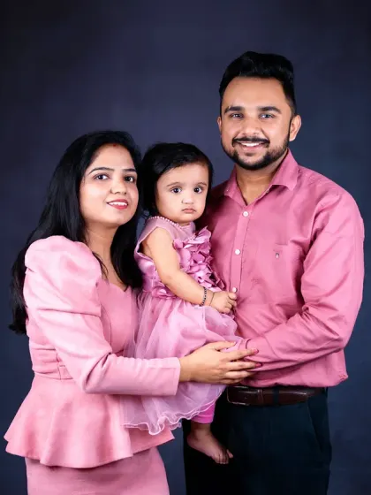 A warm and loving family portrait. The parents hold their baby girl close, showcasing the comfort and security of a family embrace.