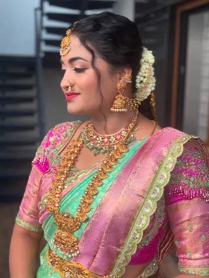 A client looking radiant in her traditional attire, with her hair in a classic bun adorned with a jasmine gajra.