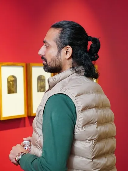 Another shot of a guest admiring the framed artworks, showcasing the gallery ambiance of our exhibitions.