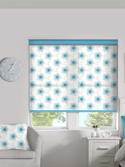 A cheerful blue floral pattern on a roller blind, perfect for a bedroom. The matching cushion shows how window treatments can be coordinated with other decor elements.