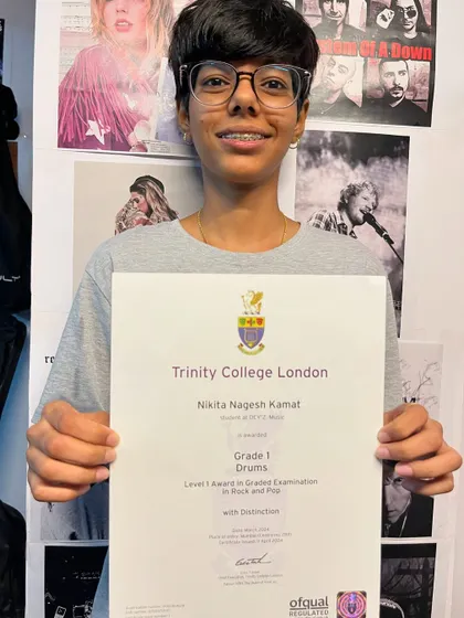 Here is Nikita, proudly holding her Trinity College certificate for Grade 1 Drums, which she passed with Distinction. A testament to her dedication.