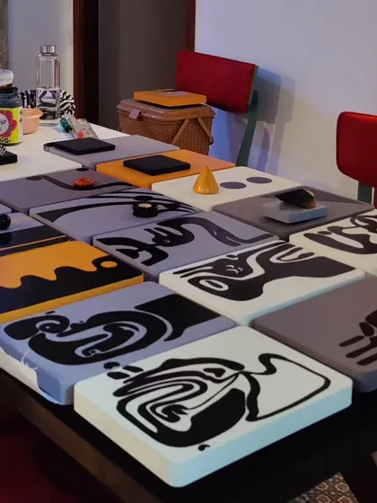 The collection of hand-painted panels for the Hyderabad project laid out on a table in the studio before installation.
