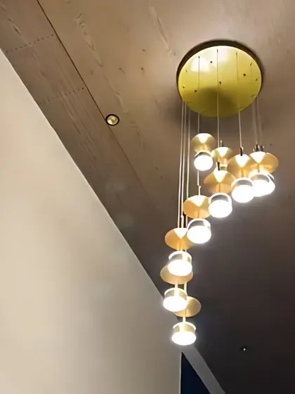 A beautiful spiral chandelier with gold accents, serving as a major statement piece in this modern home.