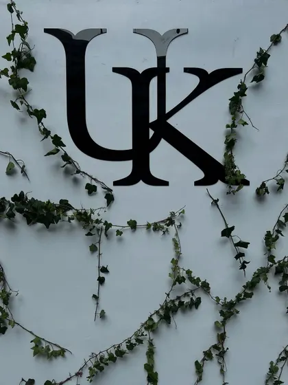 The custom 'UK' monogram for the couple, elegantly displayed on a white wall with climbing ivy for a natural, organic feel.