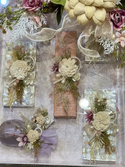 An exquisite trousseau packing solution. This clear acrylic box is filled with gifts, each individually wrapped and adorned with delicate sola wood flowers and pearls for a soft, romantic aesthetic.
