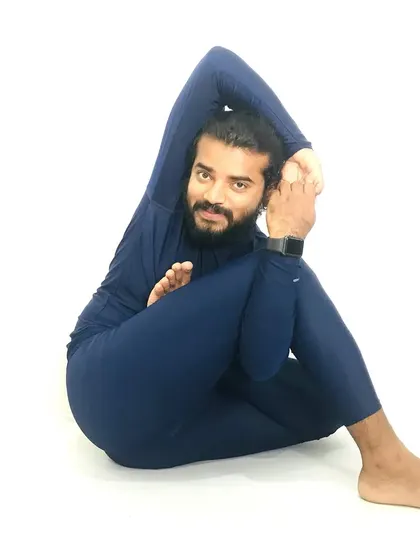 A photo of me in an advanced twisting yoga posture.