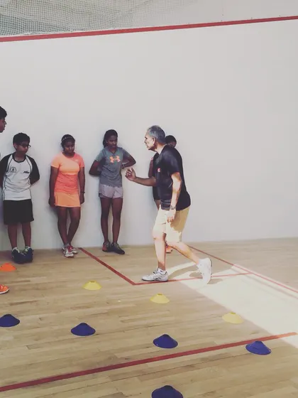A coach explains the nuances of a footwork drill before the session begins. We ensure every player understands the purpose behind each exercise to maximize their learning and performance.