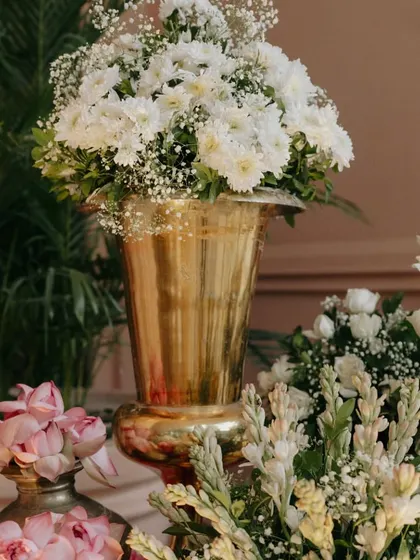 A detail shot of a floral arrangement in a large brass vase, showcasing the quality and beauty of the flowers we use.