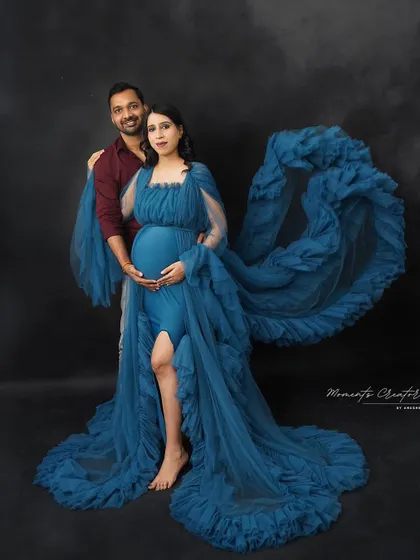 A powerful and artistic couple's portrait. The flowing blue fabric creates a dramatic effect, framing the couple in this stunning studio shot.